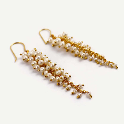 Pair of pearl and gold earrings on a white background