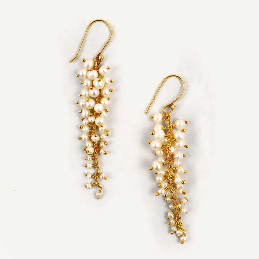 Pair of gold and pearl earrings on a white background
