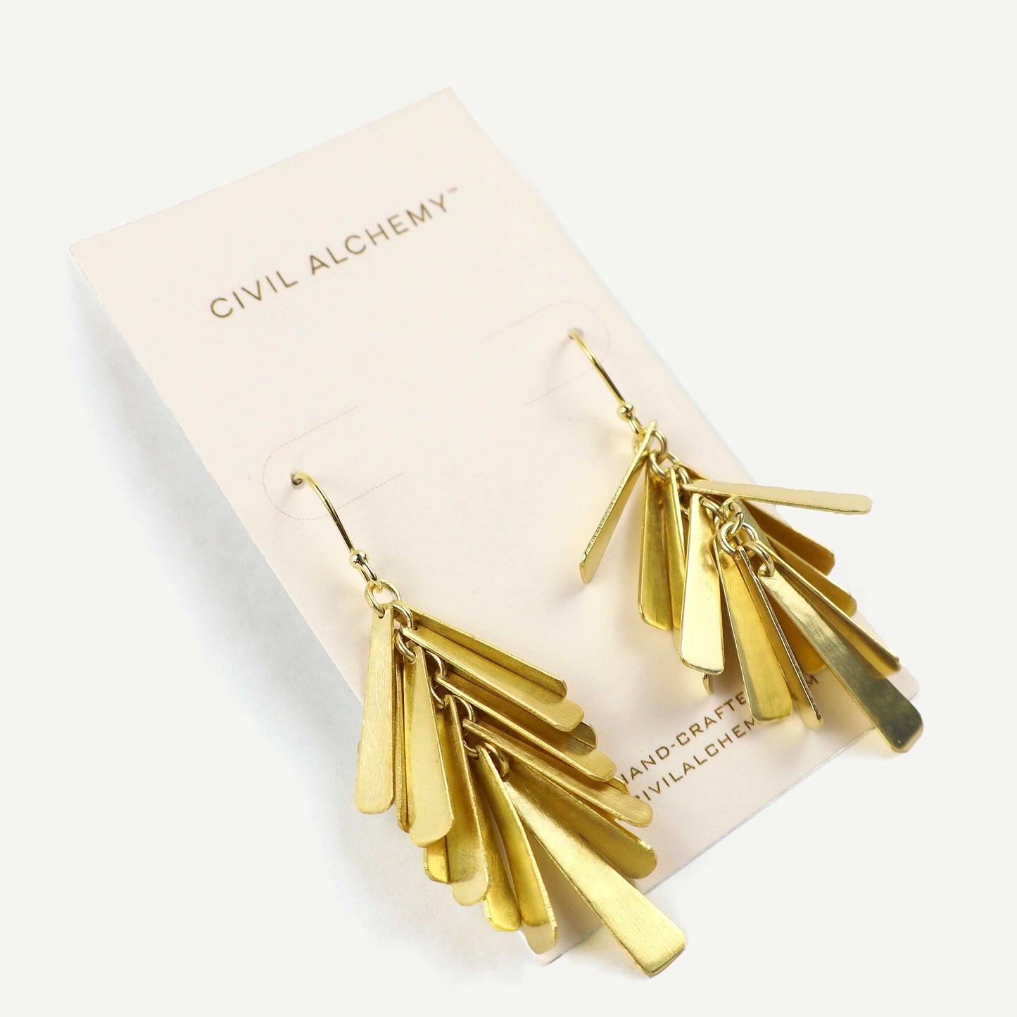 Gold fringe earrings on a Civil Alchemy branded card