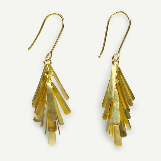 Gold fringe earrings on a white background