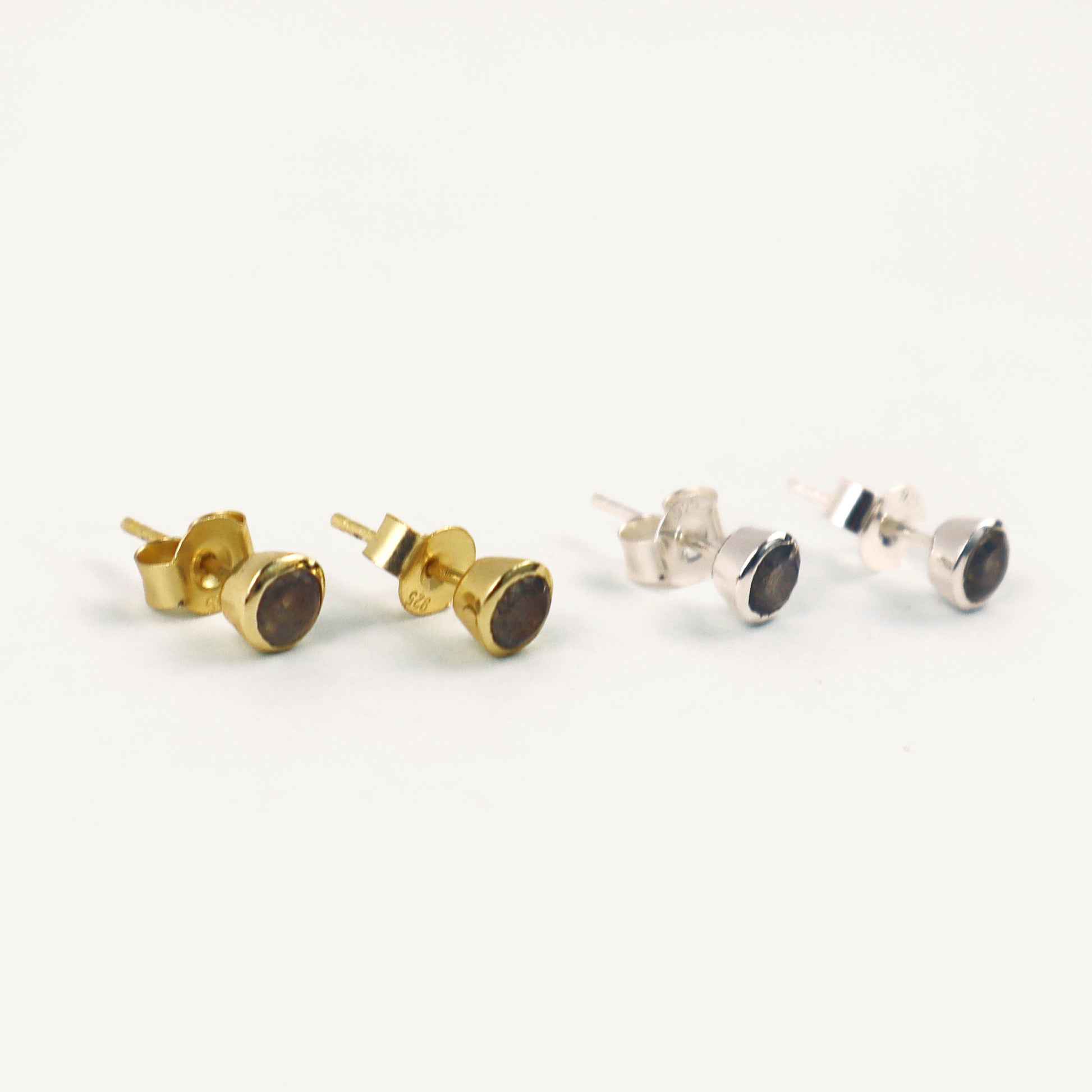 Pair of gold and silver stud earrings on a white background