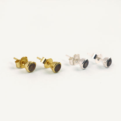 Pair of gold and silver stud earrings on a white background