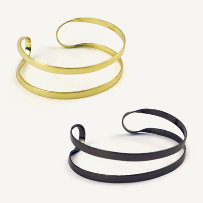 Two gold and black spiral necklaces on a white background