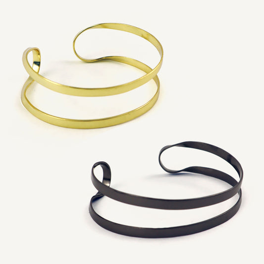 Two gold and black spiral necklaces on a white background
