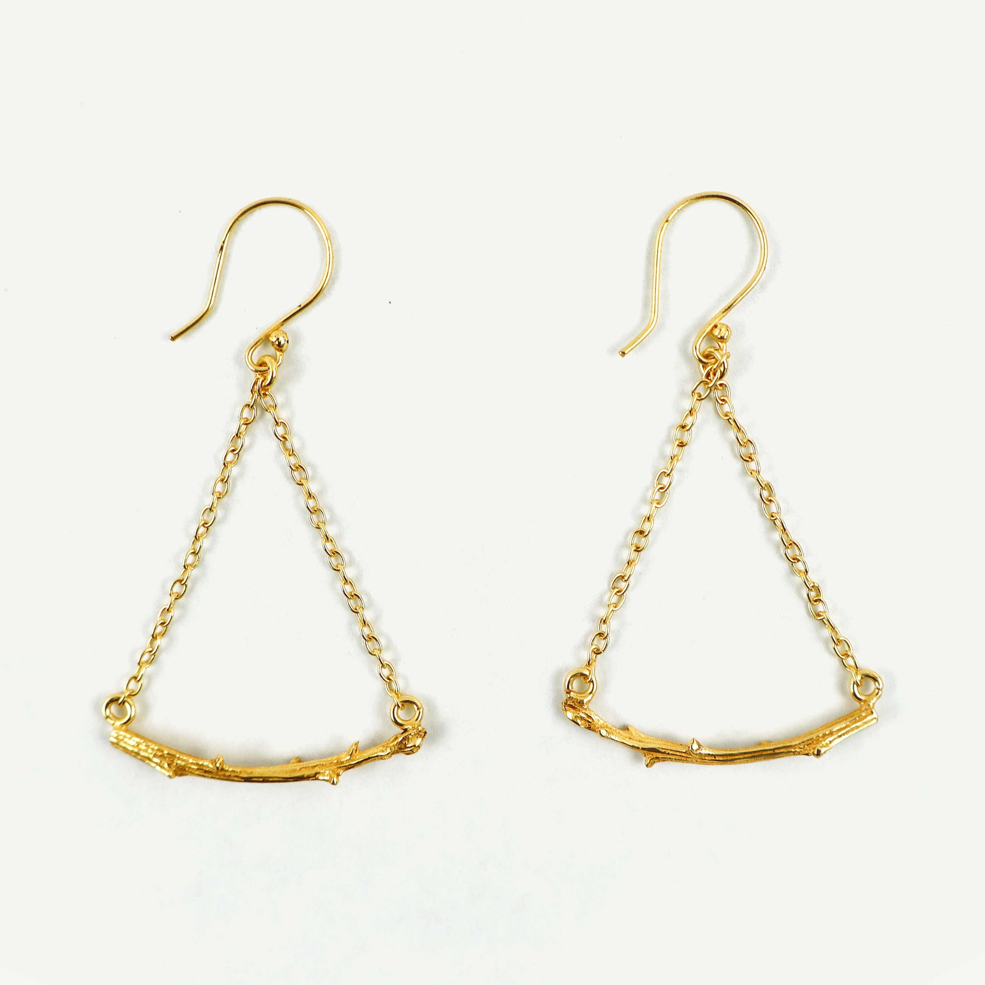 Gold earrings with chain designs on a white background