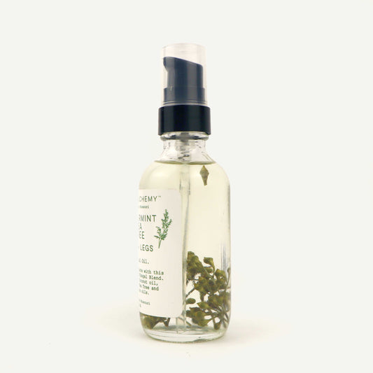 Glass spray bottle with herbs on a white background