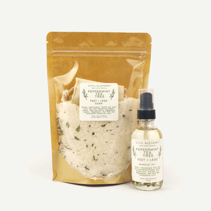 Packaged bath salt and bottle of peppermint tea tree oil on a white background