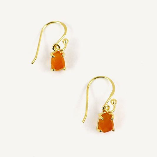 Gold earrings with orange gemstones on a white background