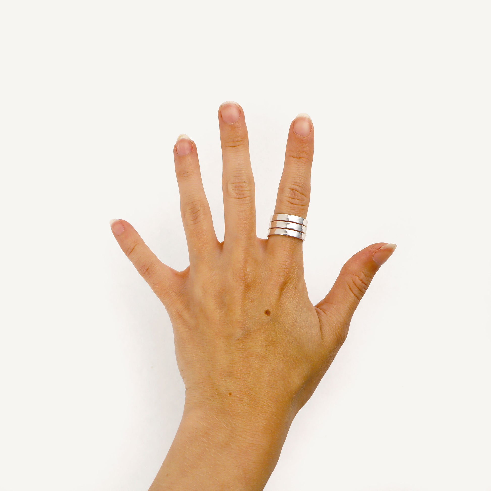 Hand with a silver ring on a white background