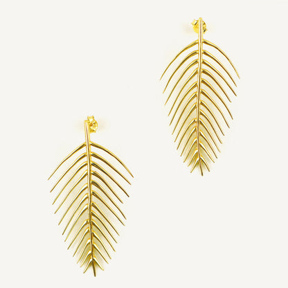 Gold leaf-shaped earrings on a white background
