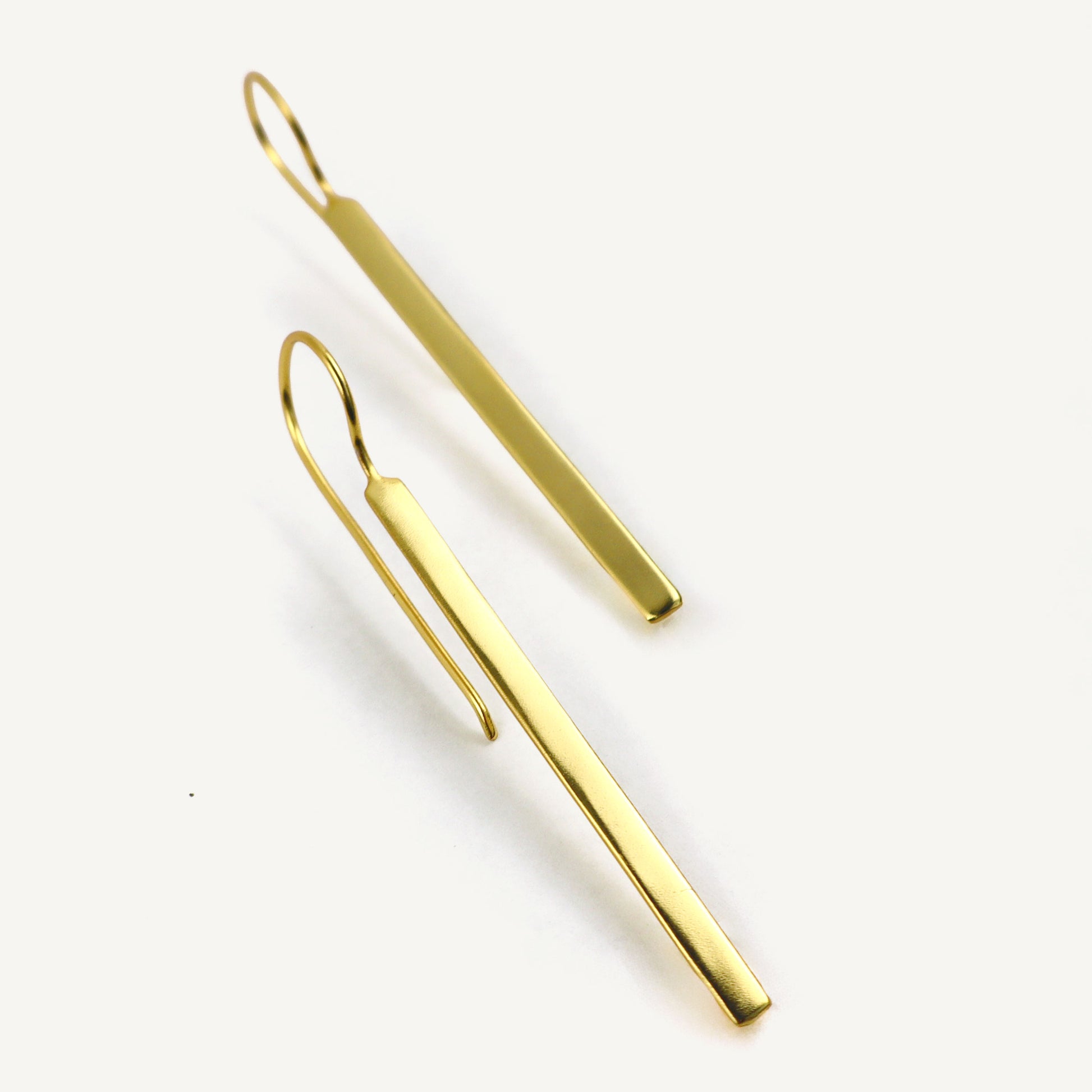 Gold bar earrings on a white background