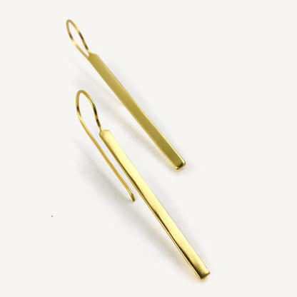 Gold bar earrings on a white background