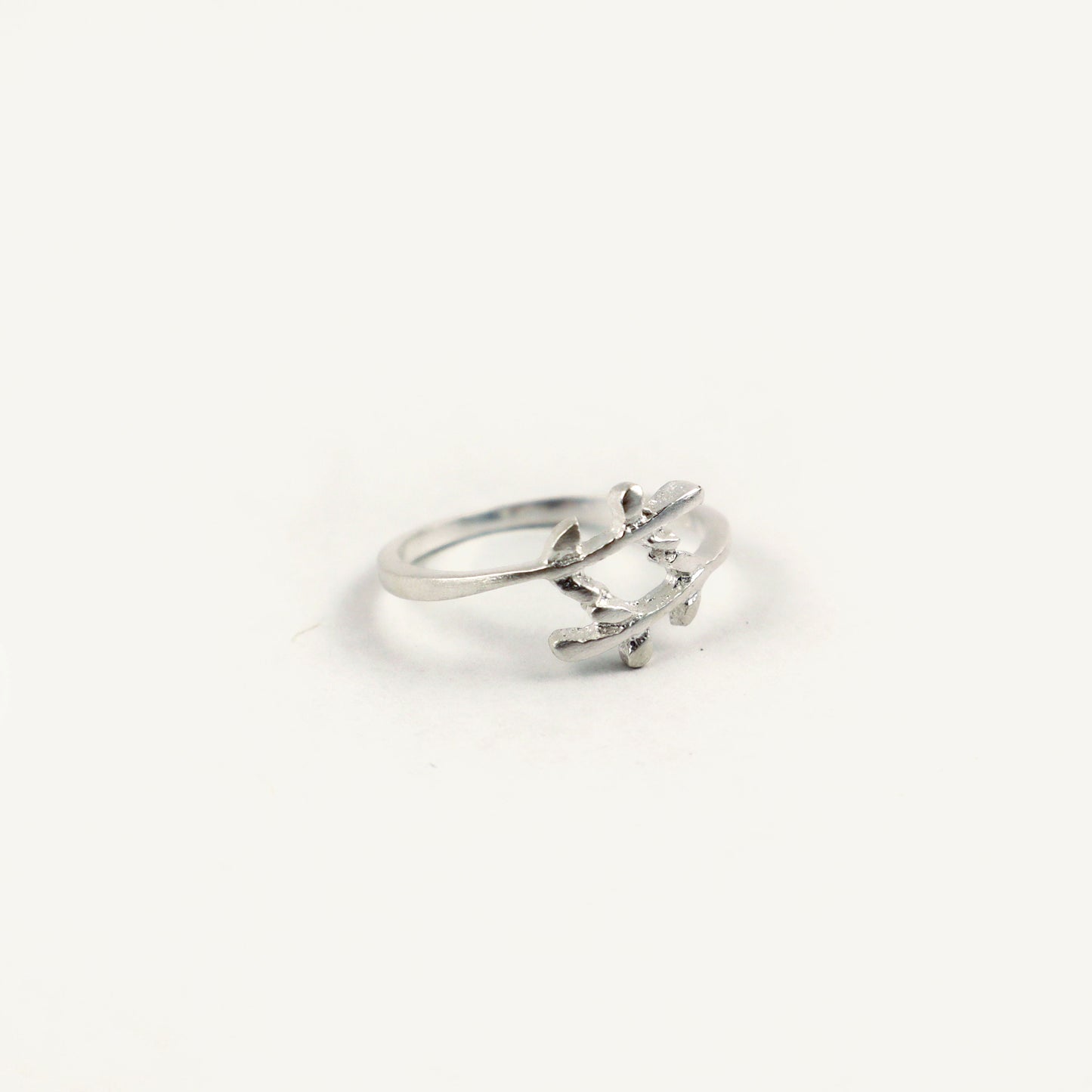 Silver ring with a leaf design on a white background