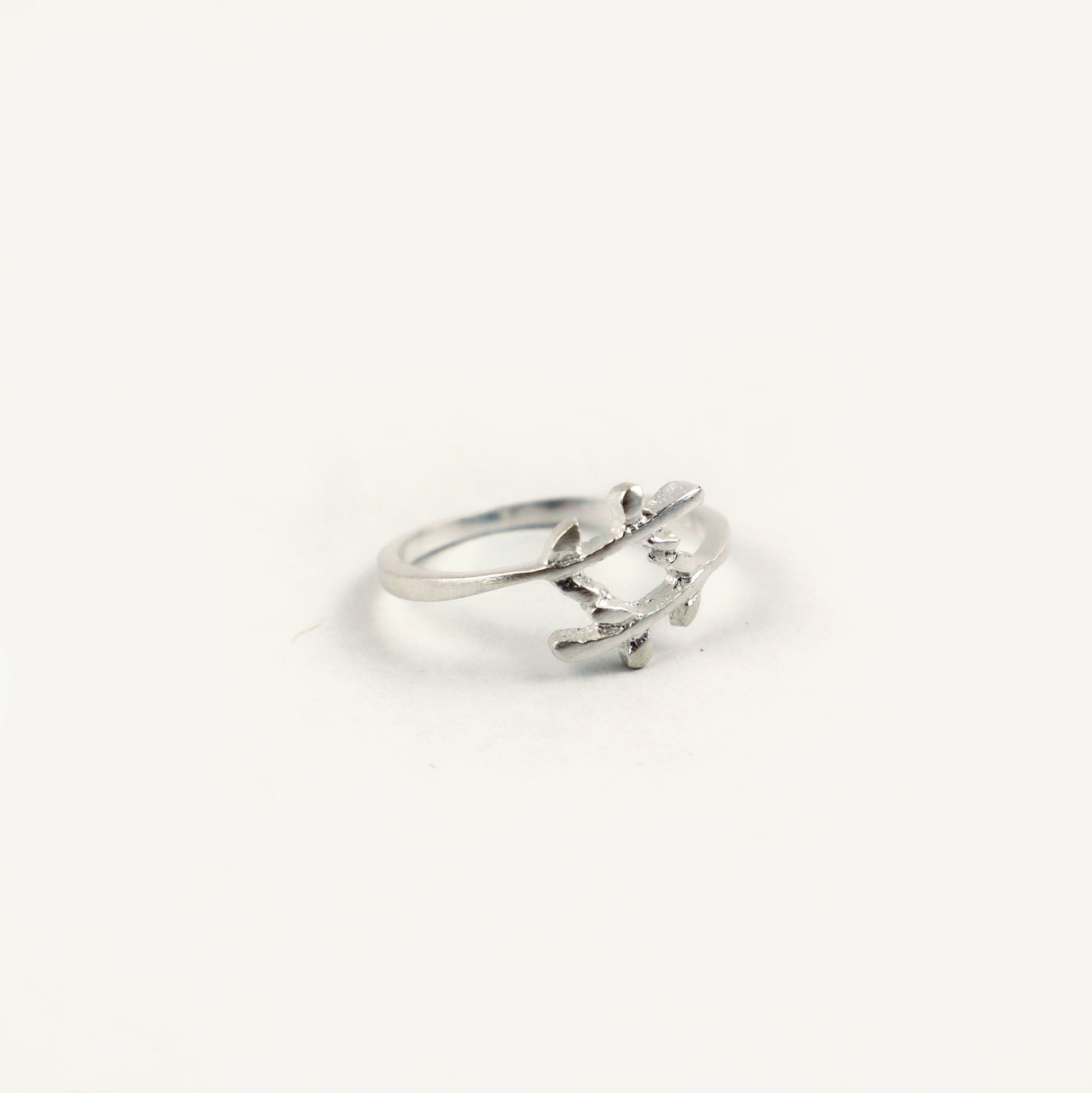 Silver ring with a leaf design on a white background