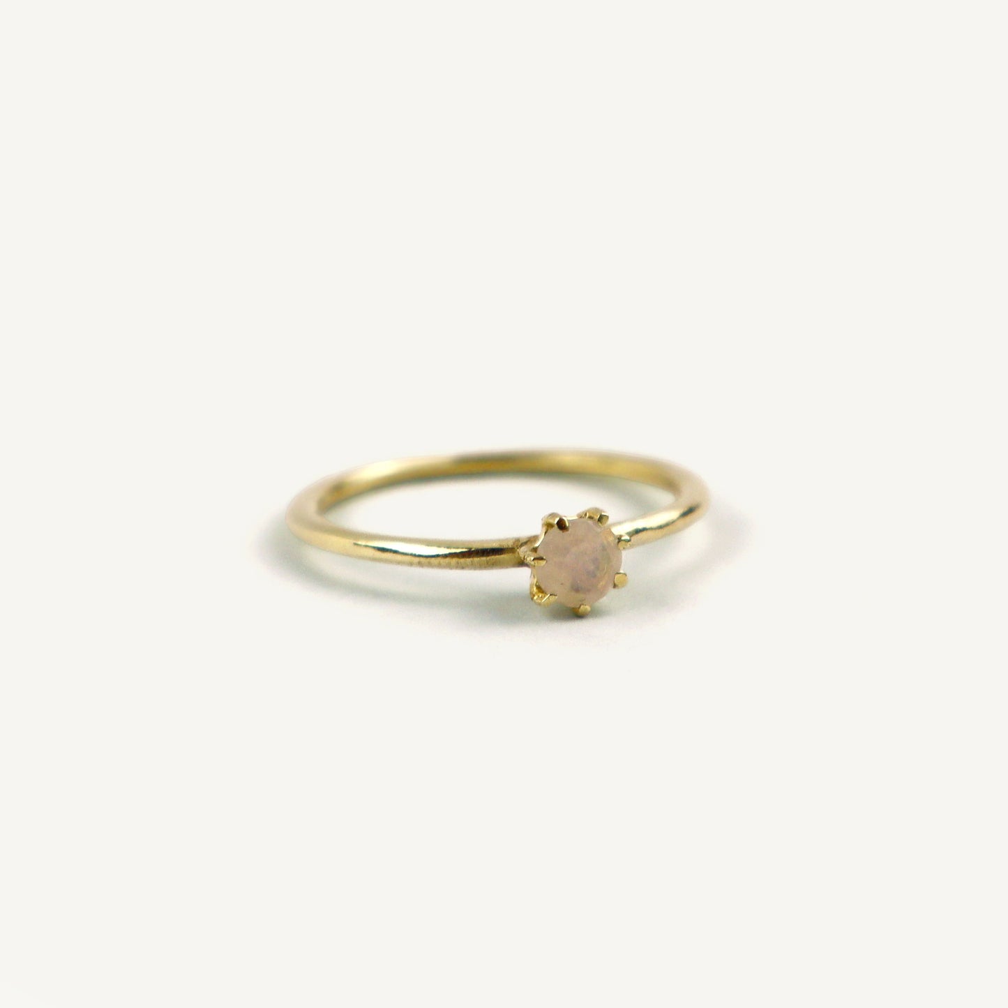 Gold ring with a small gemstone on a white background