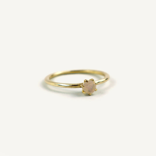 Gold ring with a small gemstone on a white background