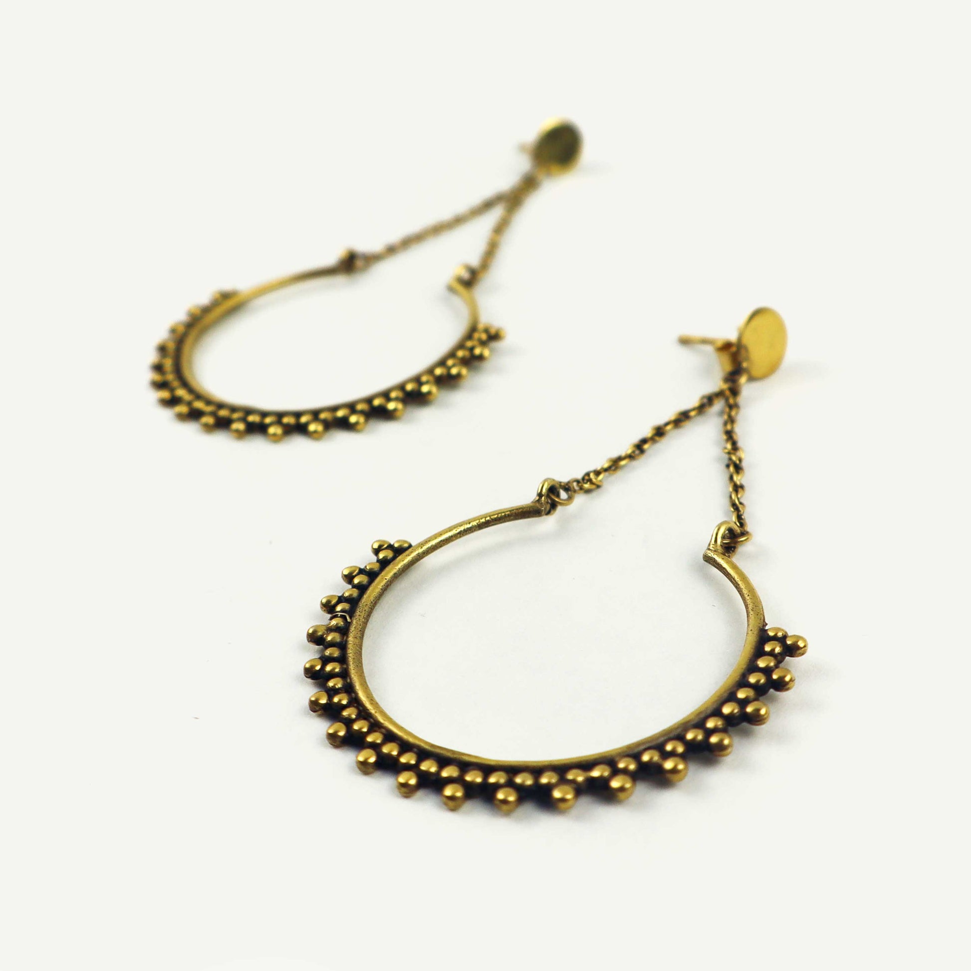 Gold hoop earrings with bead detailing on a white background