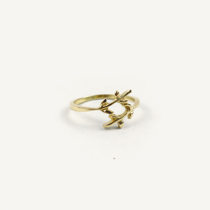 Gold ring with leaf design on a white background