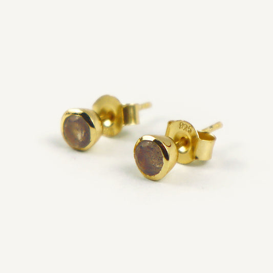 Gold stud earrings on a white background