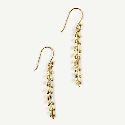 Gold leaf-shaped earrings on a white background