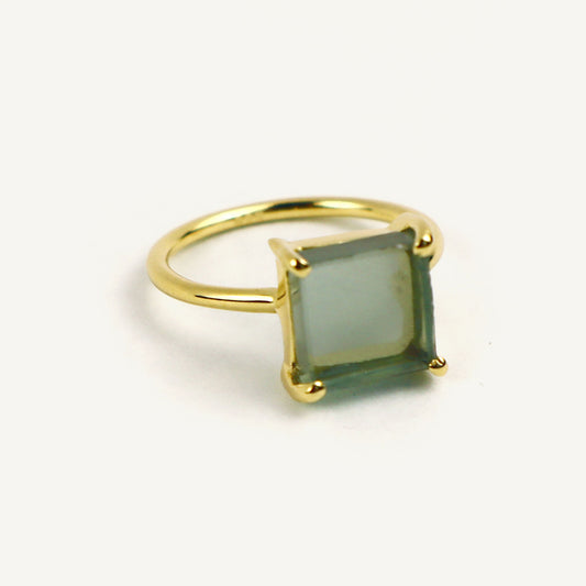 Gold ring with a green gemstone on a white background