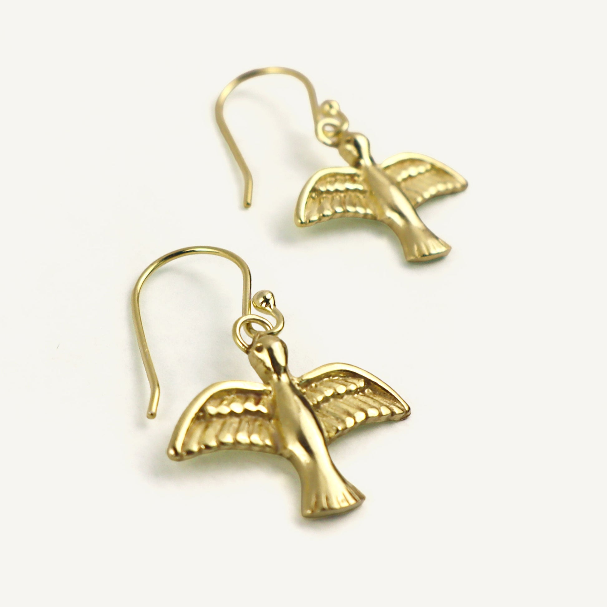 Gold bird-shaped earrings on a white background
