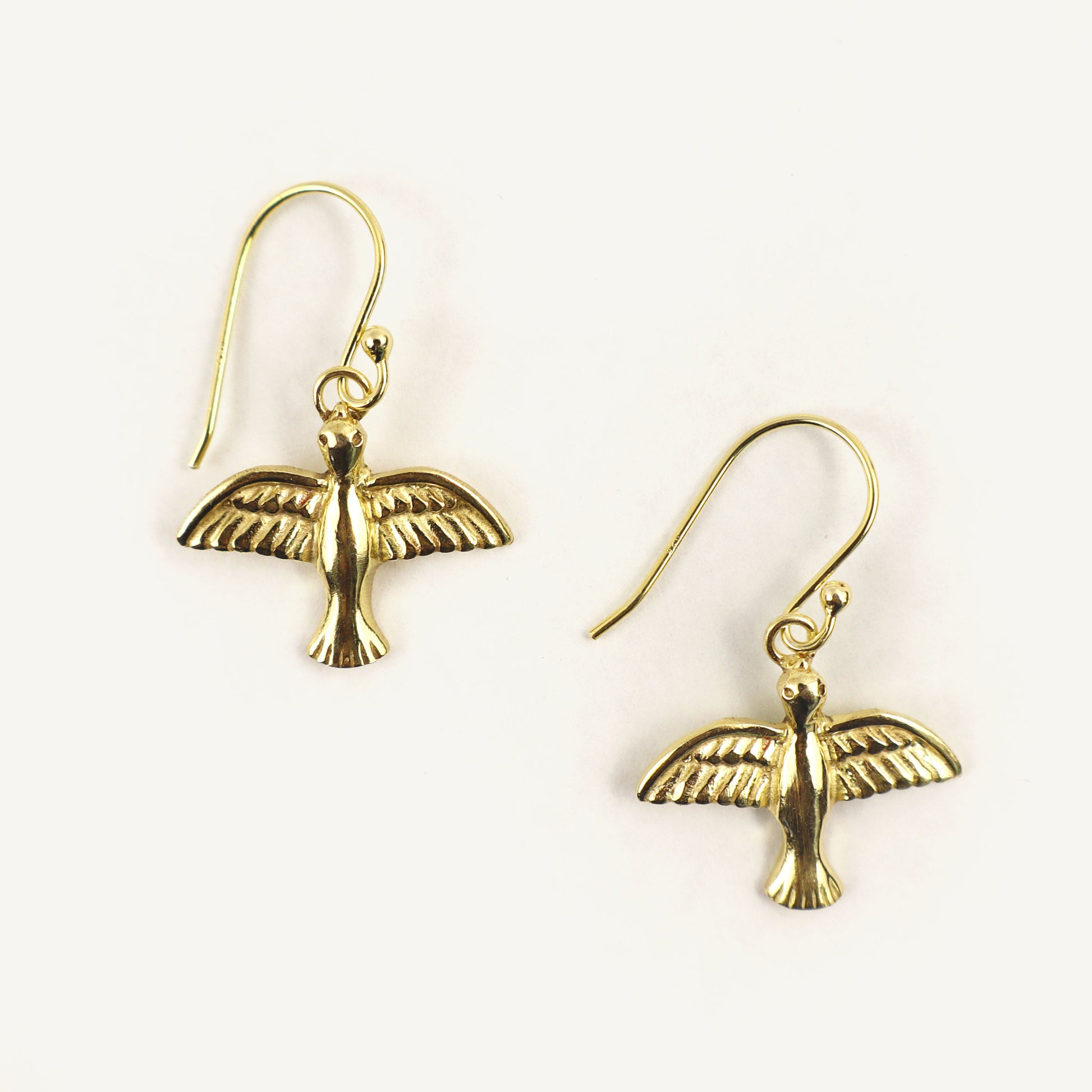 Gold bird-shaped earrings on a white background