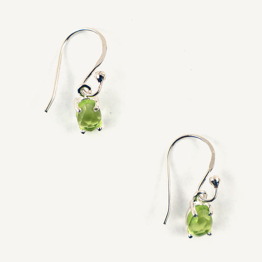 Pair of silver earrings with green gemstones on a white background