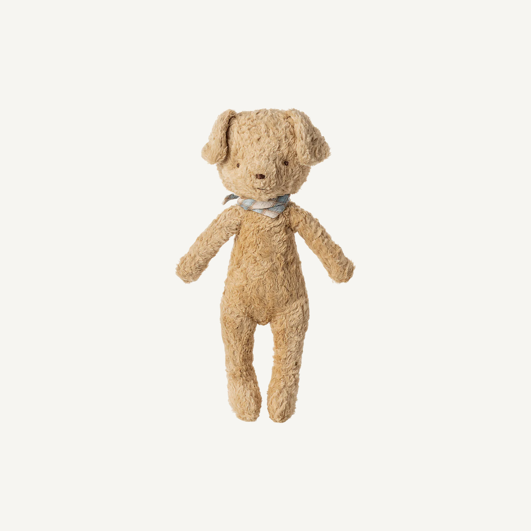 Beige teddy bear with a blue ribbon on a white background