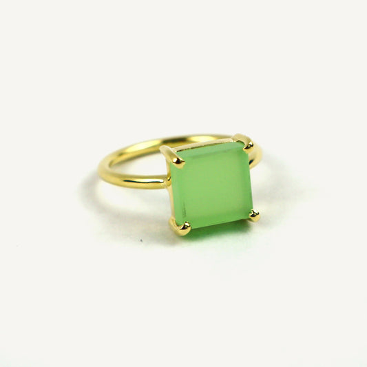 Gold ring with a green gemstone on a white background