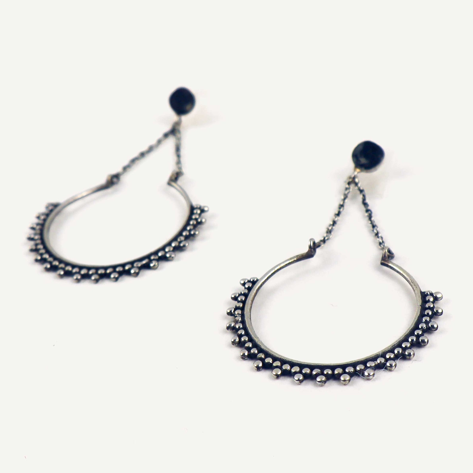 Pair of silver hoop earrings on a white background.