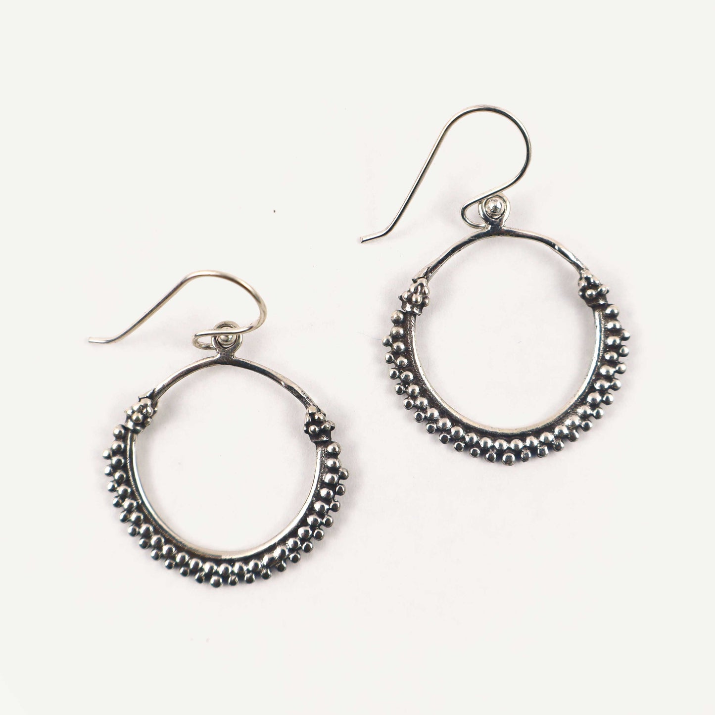 Pair of silver hoop earrings on a white background