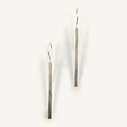 Pair of silver bar earrings on a white background