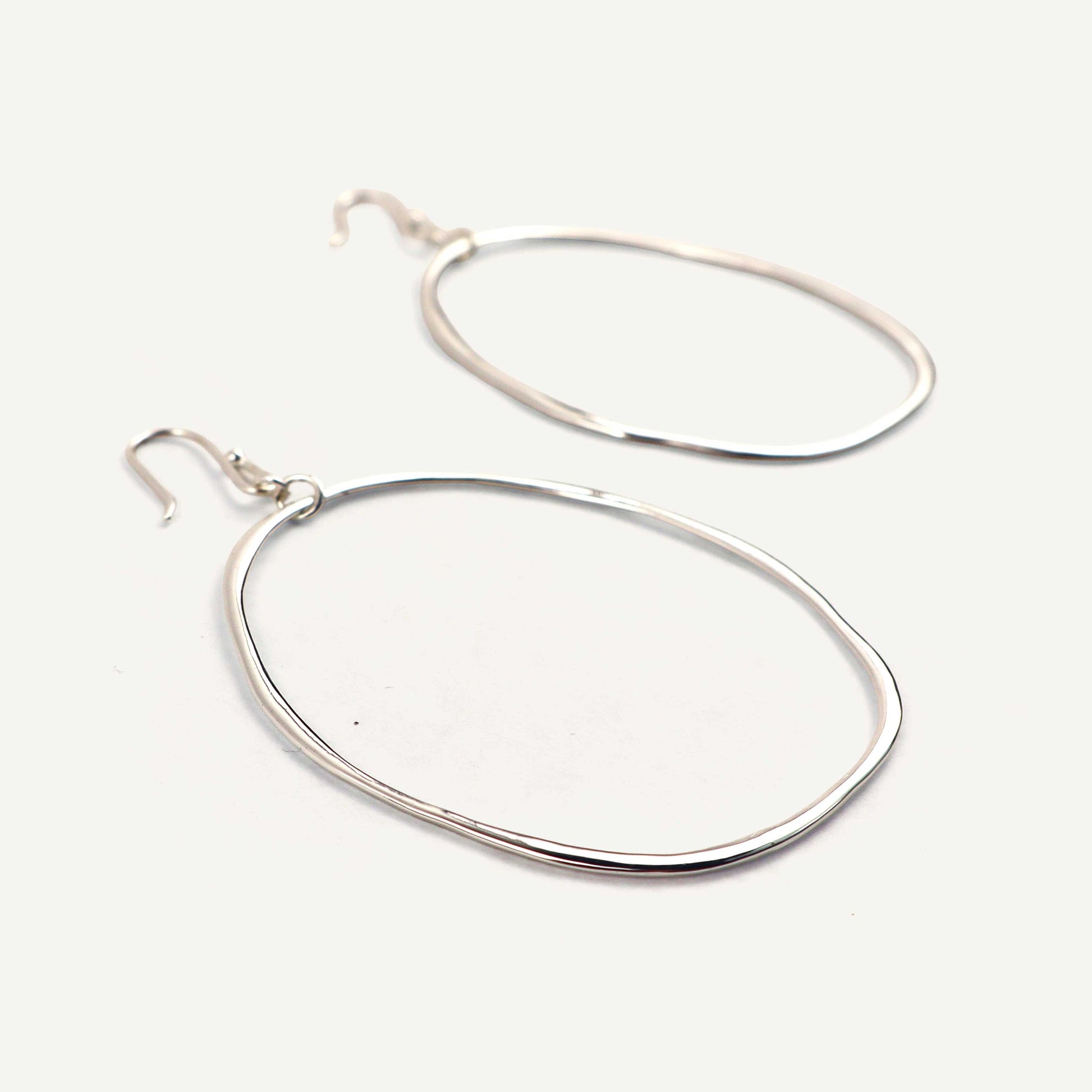 Pair of silver hoop earrings on a white background