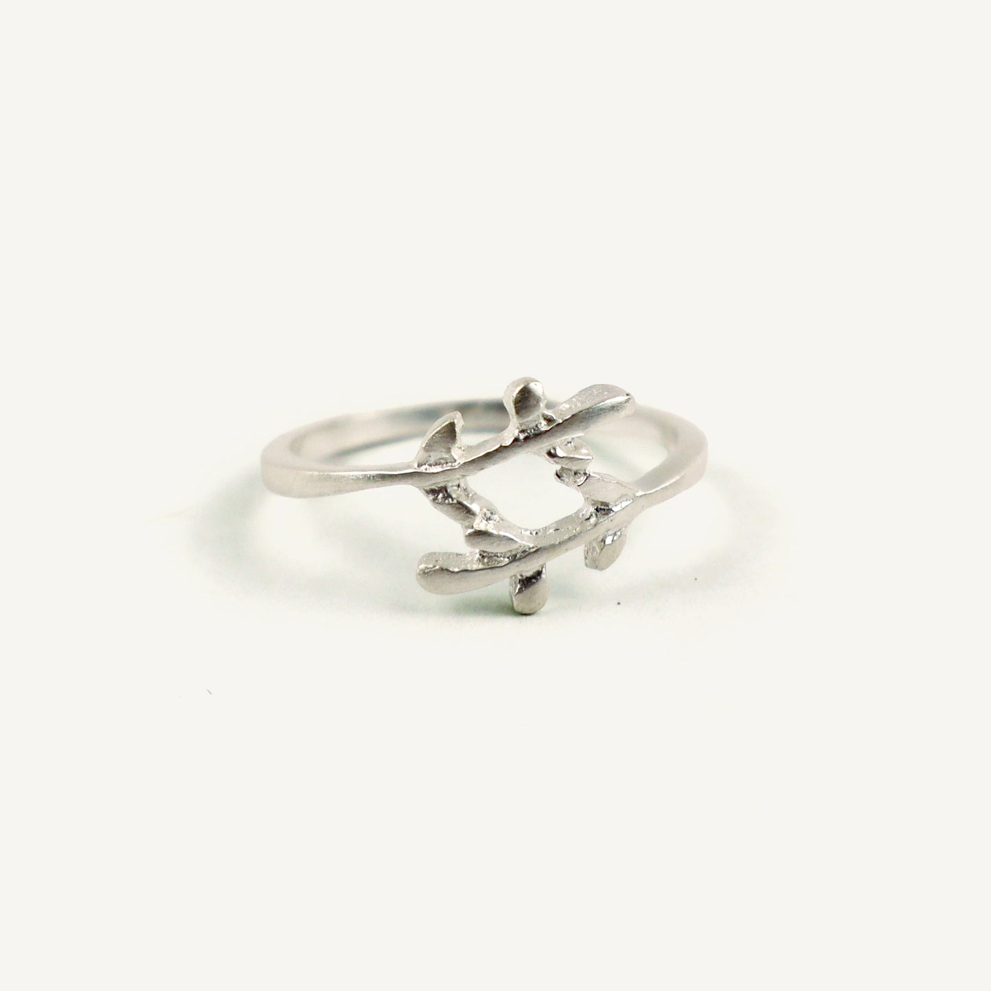 Silver ring with a leaf design on a white background