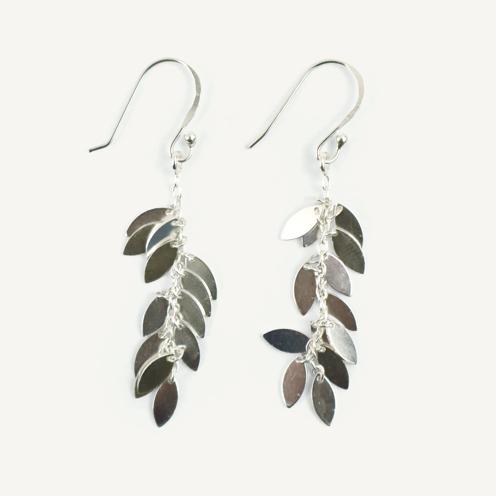 Silver leaf-shaped earrings on a white background