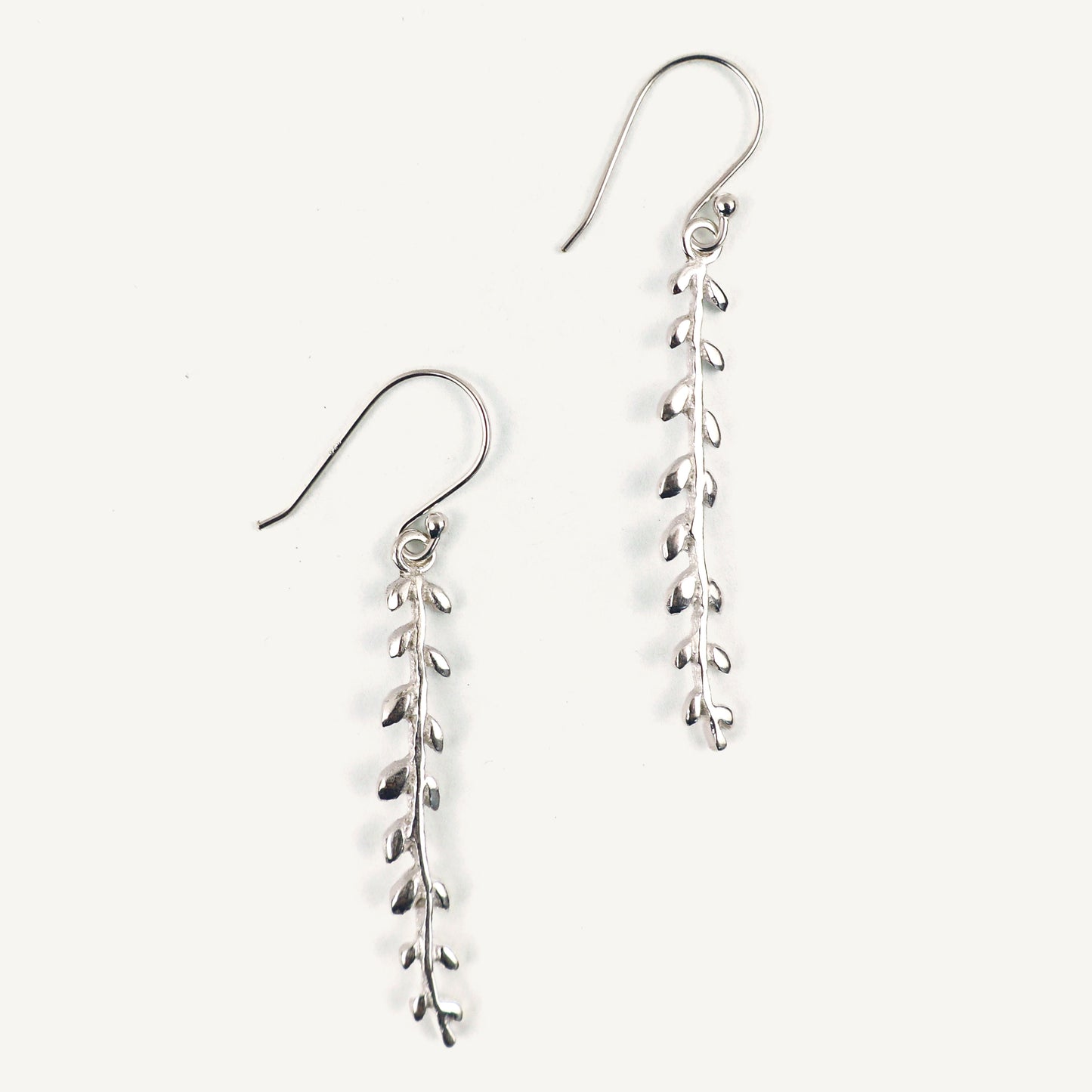 Silver leaf-shaped earrings on a white background