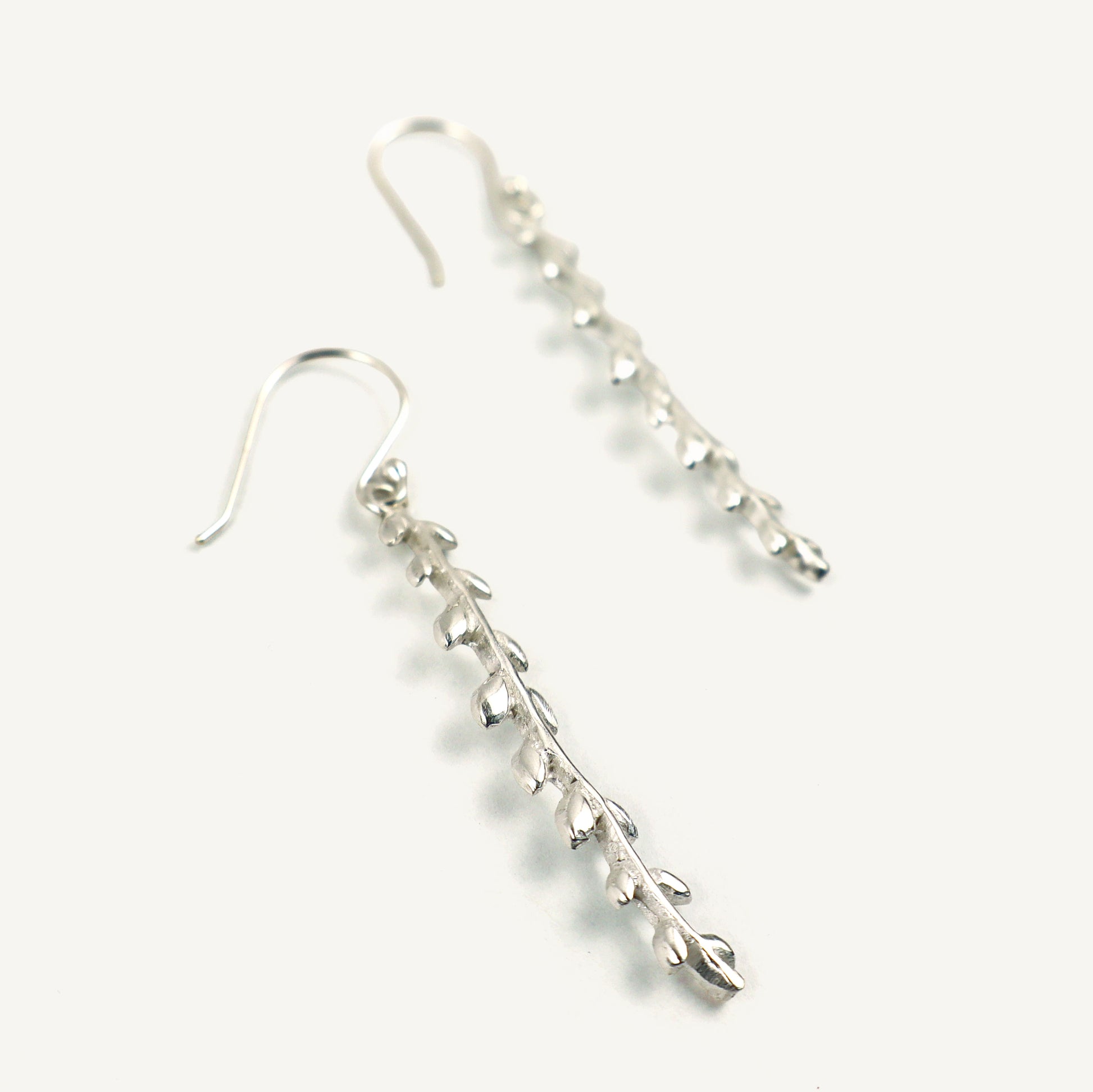 Silver leaf-shaped earrings on a white background