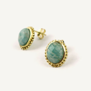 Gold-framed earrings with green gemstones on a white background