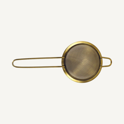 Gold-colored mesh strainer on a white background