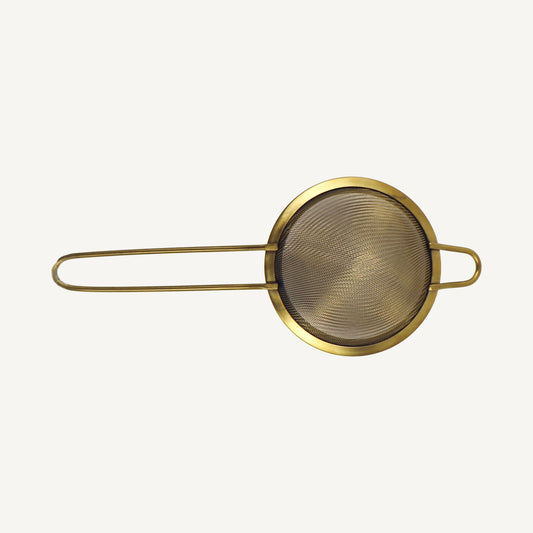 Gold-colored mesh strainer on a white background