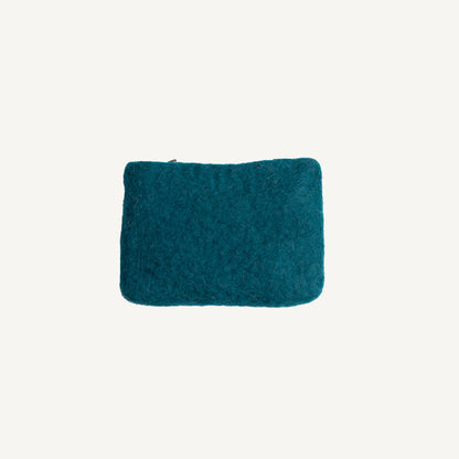 A solid black wool coin pouch with a brass zipper, hand-felted by artisans in Nepal.