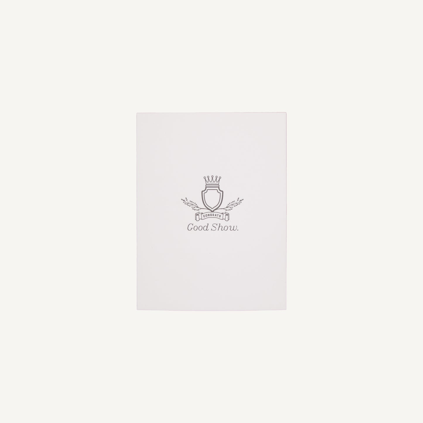 A white letterpress congratulations card with a small decorative emblem and text on the front, placed on a clear background.