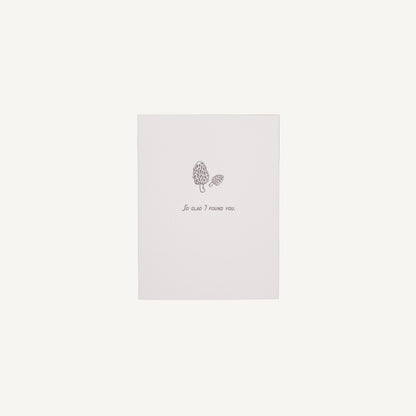 A white letterpress card with a floral design and the text 'So Glad I Found You' on it, placed against a plain background.