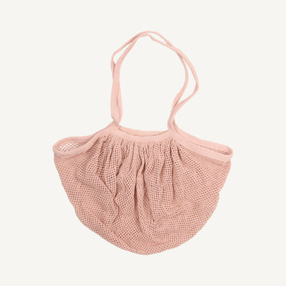 A pink cotton market bag with a fishnet-style design, featuring a handle and a drawstring closure.