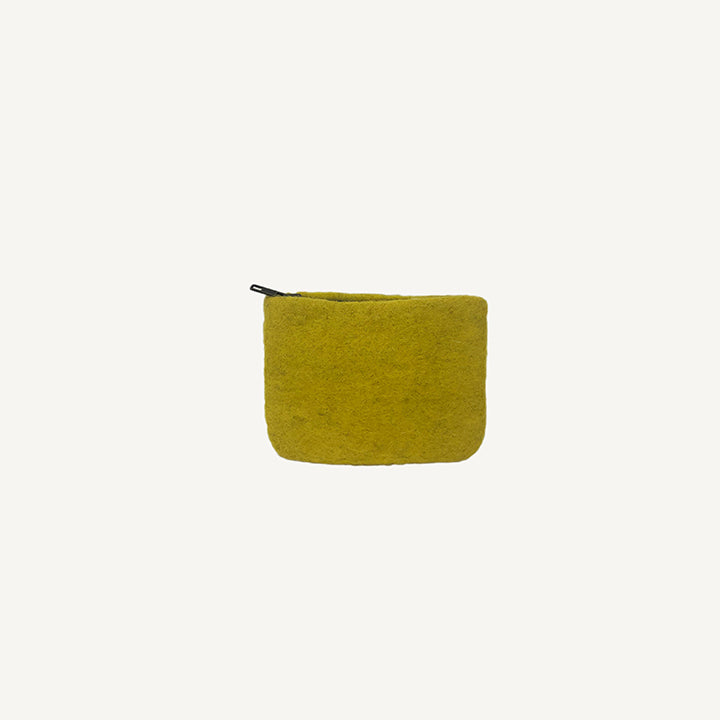 A solid black wool coin pouch with a brass zipper, hand-felted by artisans in Nepal.